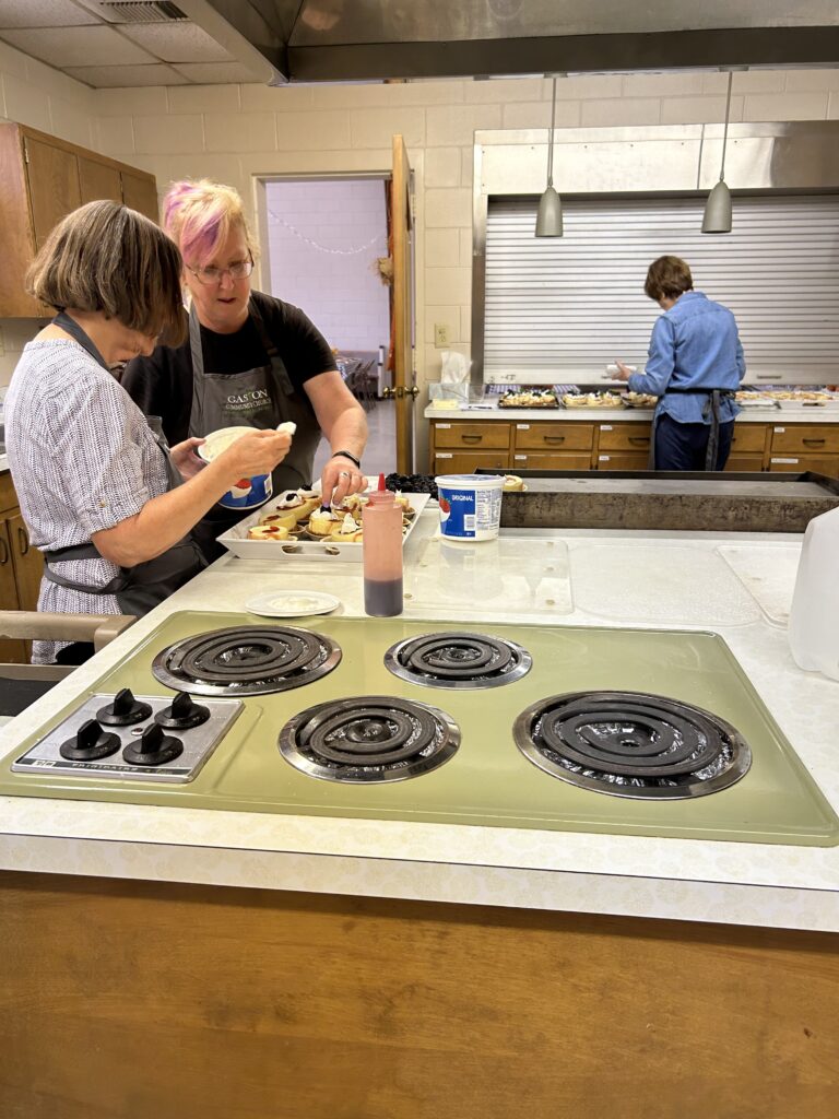 Ladies of host churches preparing desserts for lunch.